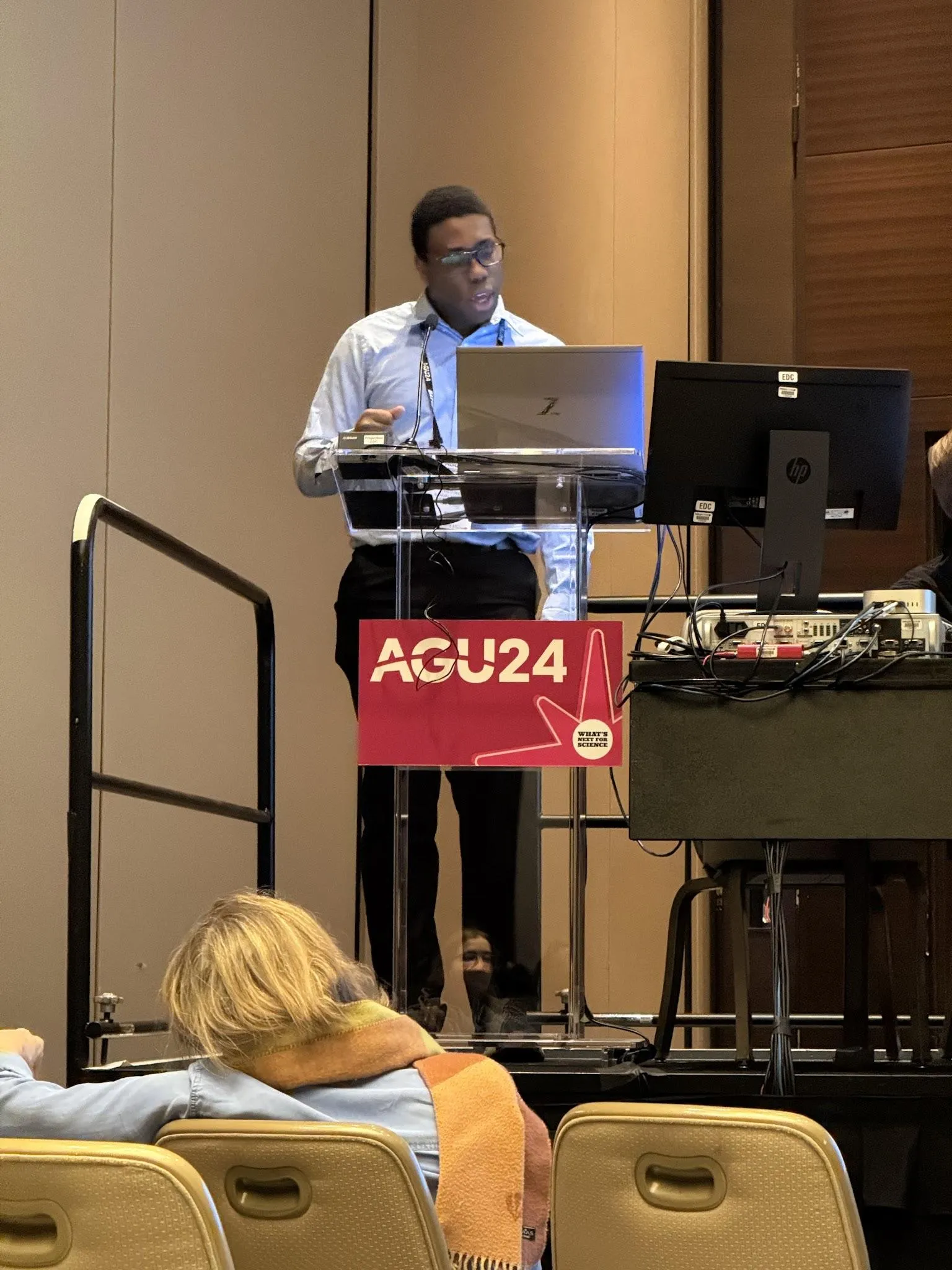 Samuel presenting his water cycle module at the podium.